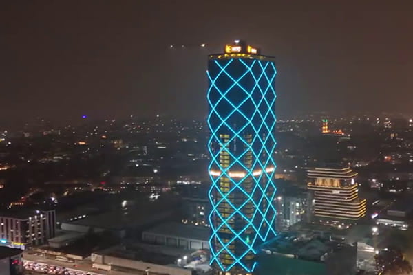 A skyscraper facade at night lit with dynamic, colorful RGB linear lights.